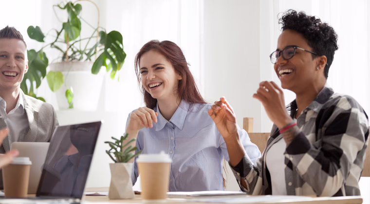 A real estate team collaborating and engaging with clients in a modern office, illustrating how unified communications improves client engagement and team communication in the property sector